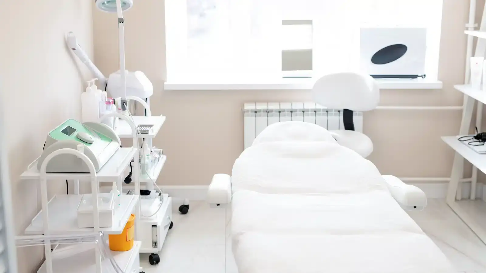 The treatment room of a medical spa with a procedure table and equipment, the setting where before-and-after photographs are taken and where consent needs to be in place first.