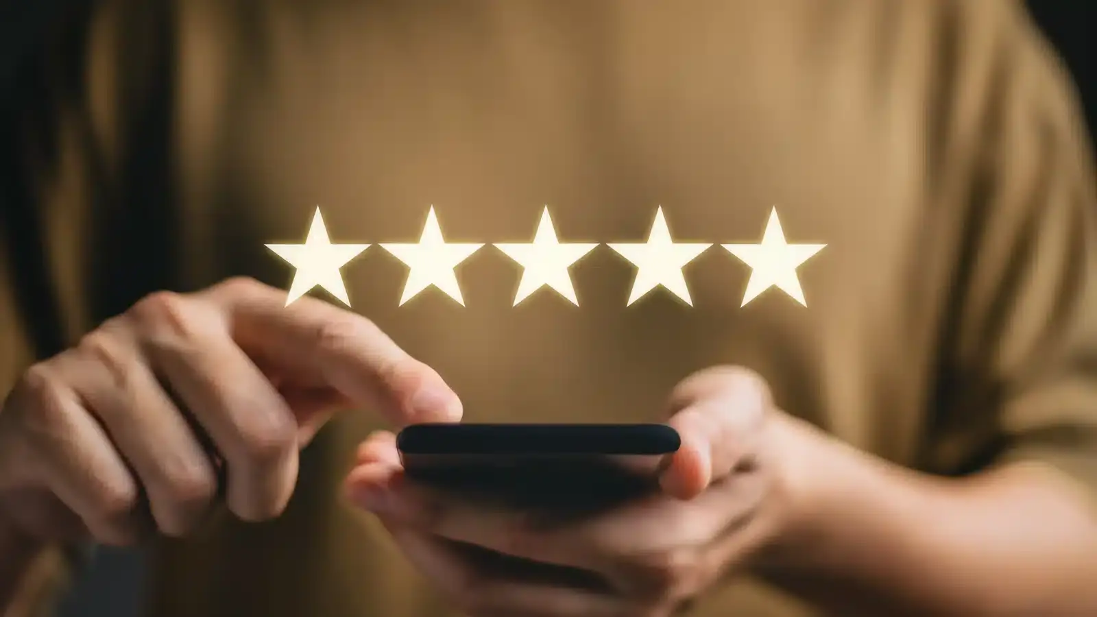 Hands holding a phone showing a five-star rating, representing the review signals that build an aesthetic clinic's prominence on Google Maps.