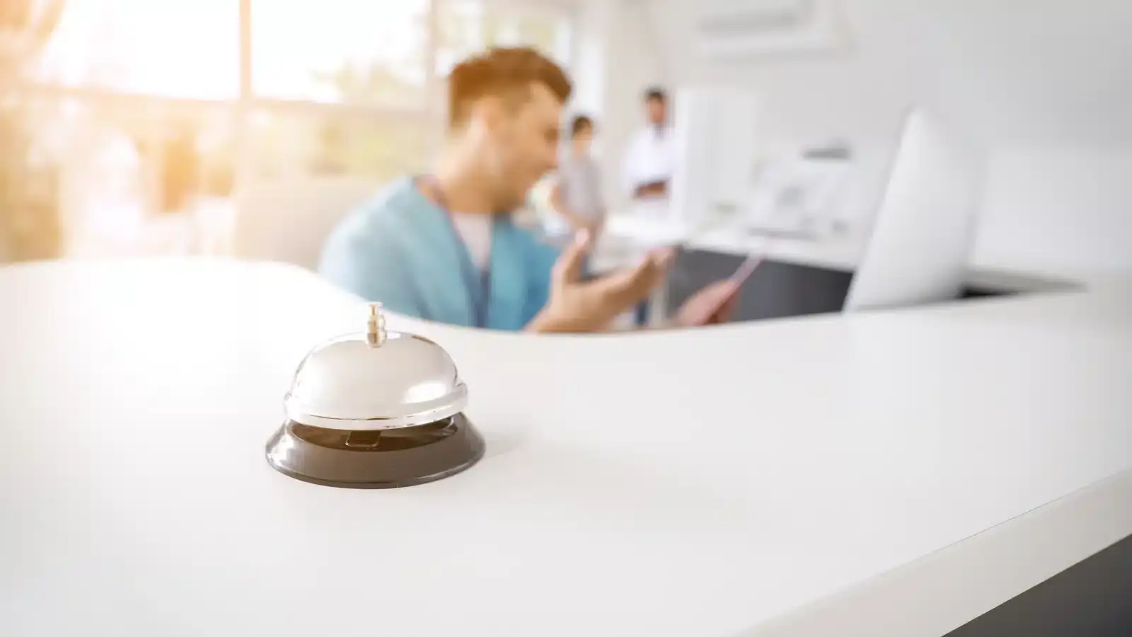 A service bell on the reception desk of a bright modern clinic, representing the front-desk details a Google Business Profile listing has to get right.