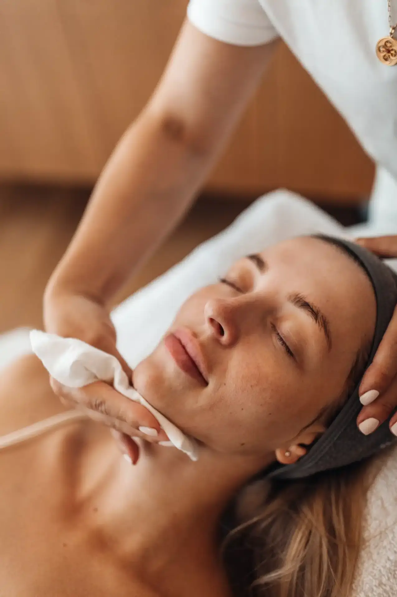 A relaxed patient receiving a calming facial skincare treatment at an aesthetic clinic