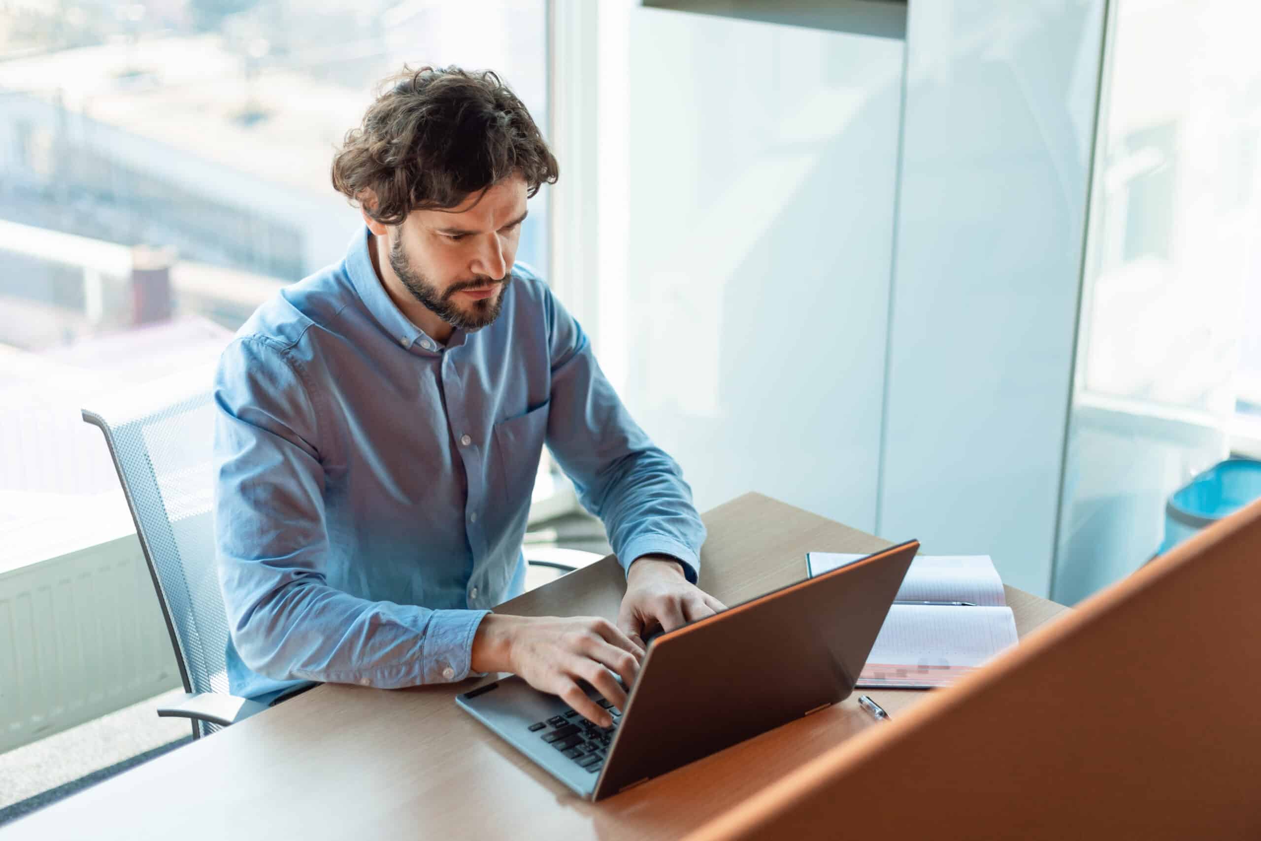 Med spa owner working alone on a laptop weighing DIY marketing